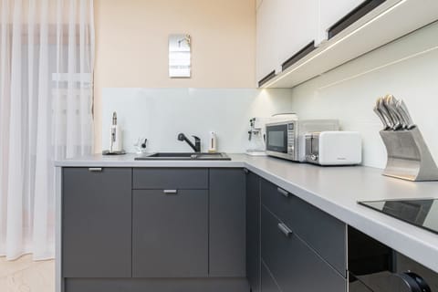 A well-organized kitchen, featuring ample workspace, a range hood, and a sleek design.