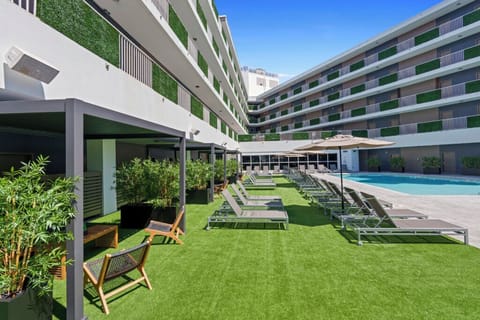 Unwind along the green terrace with pool views all day.