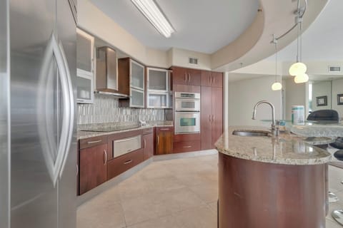 This well-designed kitchen boasts rich wood cabinetry, granite countertops, and stainless steel accents. The open layout ensures a seamless transition to the living and dining areas, creating a perfect space for gatherings.