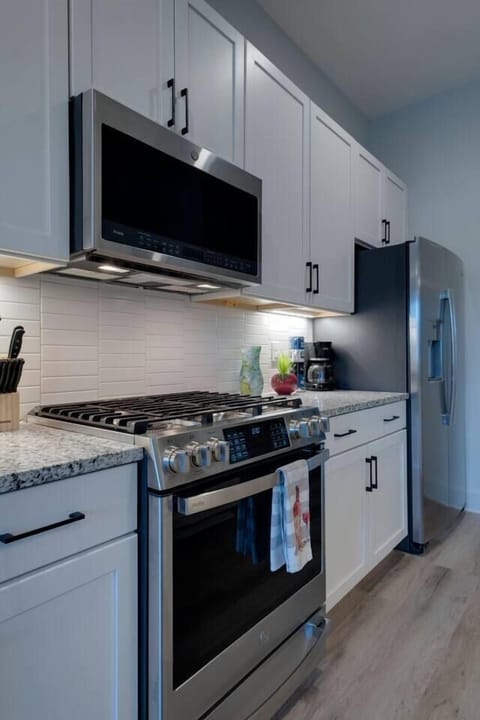 Kitchen with stove, microwave, refrigerator, and freezer along with lots of storage 