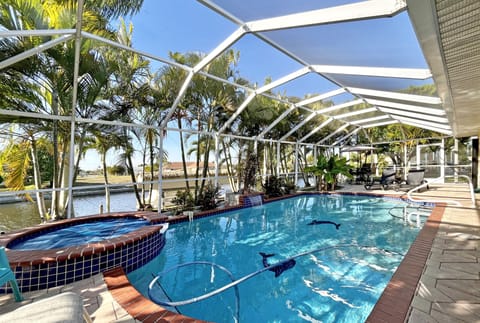 Screened heated pool and spa with paver deck and wide canal views