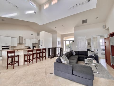 Lounge with TV and large comfortable sectional sofa open plan to kitchen 