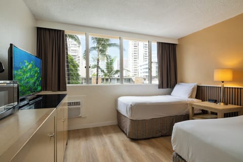 Your comfortable room features two beds, modern amenities, and city views through large windows.