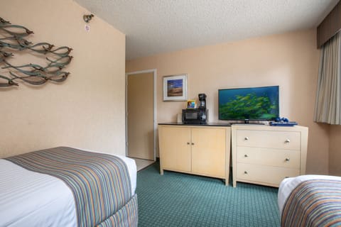 Your spacious room features comfortable twin beds, a flat-screen TV for entertainment, a microwave and coffee maker for convenience, plus coastal decor that brings a relaxed beach vibe to your stay.