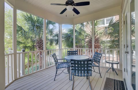 Your screened porch offers tropical dining surrounded by lush palms, with gentle breezes from the ceiling fan overhead.