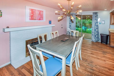 Charming Dining Space with a Cozy Fireplace & Backyard View