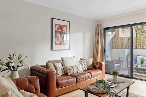Unwind in style in this inviting lounge room, featuring comfortable leather sofas, chic decor, and plenty of natural light. 