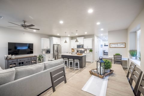 Dining Room View - The Kitchen and Dining Table can accommodate 13 adults and is stocked with pots, pans, baking sheets, mixing bowls, plates, bowls, cups, silverware, and a collection of cooking utensils.