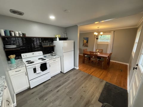 Kitchen stocked with all essentials: dining set for 6, pots and pans, utensils.
