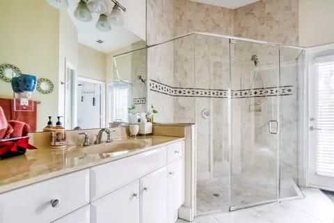 Large bathroom with walking shower (one step down) and door facing patio/pool