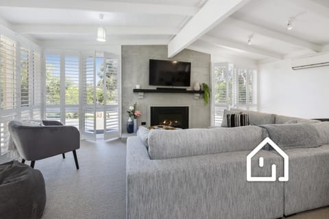 Open plan living with comfortable couch, smart TV & ambient gas fireplace