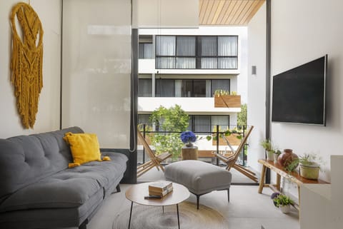 The bright sun soaked living space with a plush sofa that converts into a bed