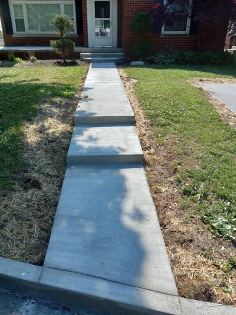 Front Concrete Walkway leads to 3 low steps, along with a handrail on right .