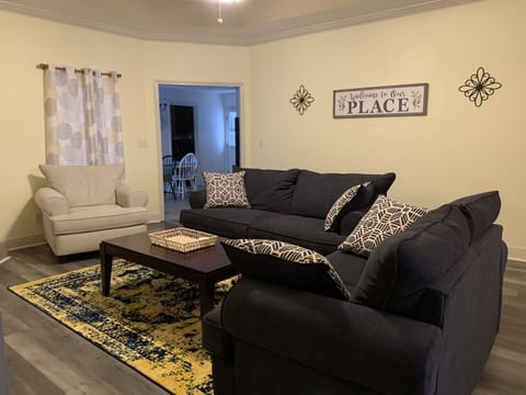 Updated flooring and furniture—sofa, loveseat, and oversized chair. 