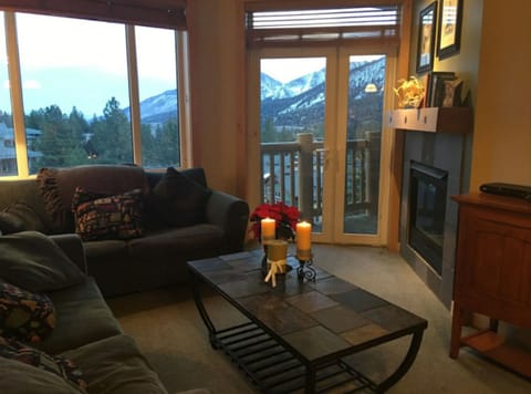Living area with fireplace, views, and access to outdoor balcony.