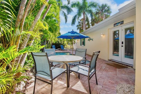 Your private outdoor dining space features a table for four, surrounded by lush tropical palms and just steps from your pool.