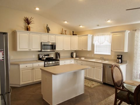 Kitchen island and adjacent dining area with light streaming in from outside