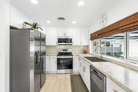 The home features a gorgeous modern style kitchen that's brightly lit and comes equipped with stainless steel appliances. And best of all you get a wide-open view of the pool!