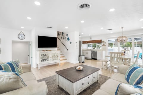 Open floor plan living & dining room with plenty of seating and a beautiful view of the pool