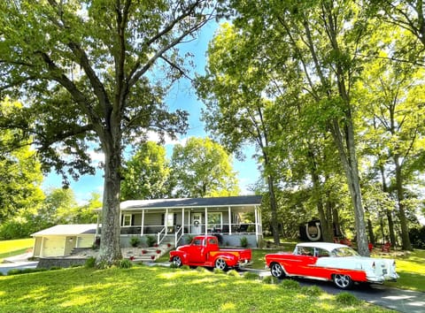 Exterior view of home during summer months. Hot Rods for staging only. 