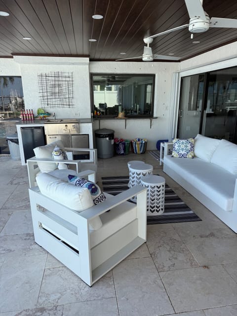 Covered patio area with three ceiling fans and an outdoor wet bar area