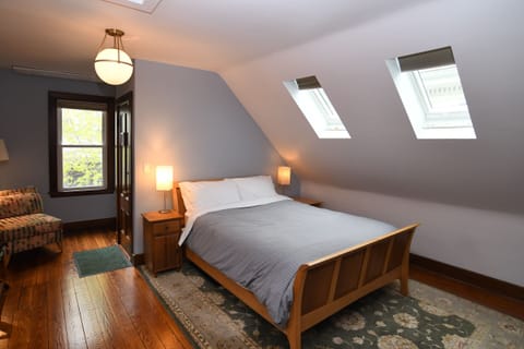 Large and bright bedroom has shades on the windows for sleeping.