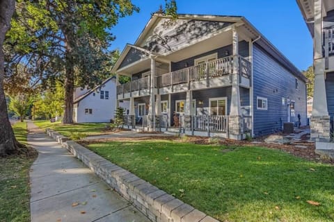 Charming blue duplex featuring covered porches and well-maintained grounds in a peaceful tree-lined neighborhood.