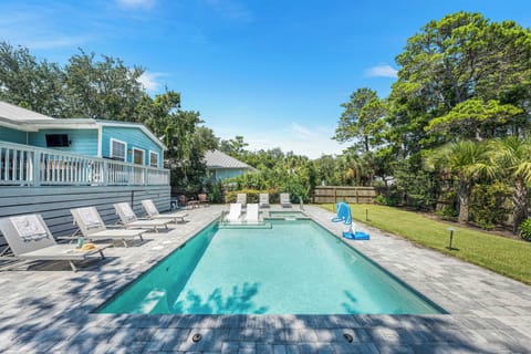 Private backyard features a large swimming pool with lounge chairs.