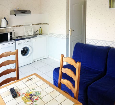 The living room, dining table, kitchen area and two single sofa beds