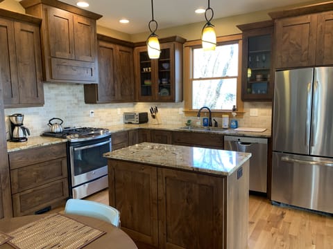 Gourmet Kitchen with gas range and vent hood. Built-in Microwave in island.