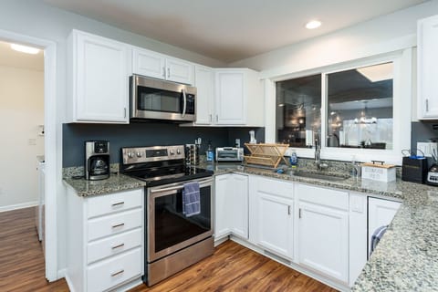 The kitchen has all the comforts of home: coffee pot, dishes & serving pieces 