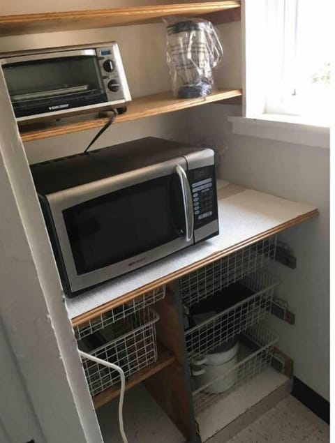 Pantry with microwave, toaster oven, blender and storage for large pans.