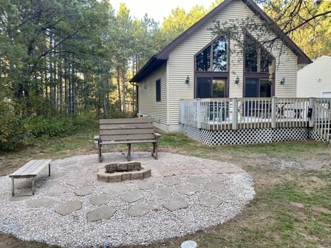 Exterior from front lawn, featuring fire pit and large deck