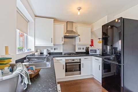 A fully equipped kitchen with fridge freezer, oven, stove, microwave, kettle, toaster, cookware, tableware, and utensils all provided