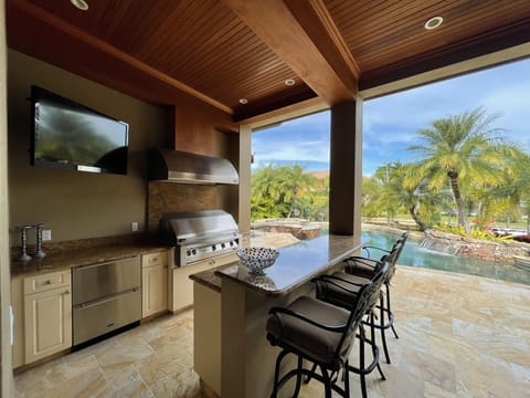 Outdoor Kitchen with TV, Large built in grill and refrigerator Drawers and bar.