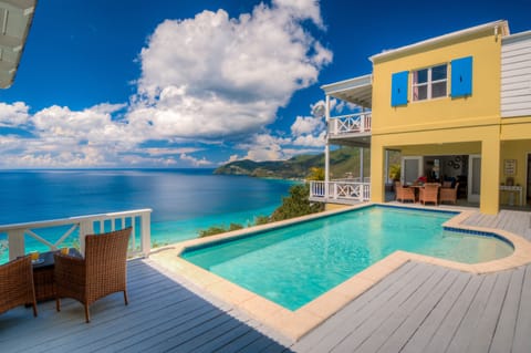 The pool deck has various seating arrangements and sun loungers