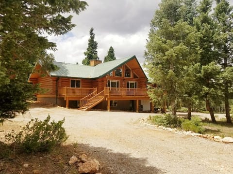 Surrounded by trees, large circular driveway, steps to deck and front door