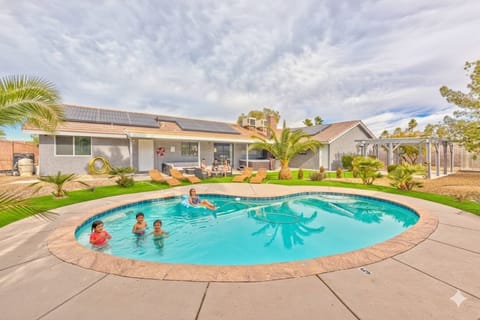 Enjoy sunny days in this beautifully landscaped backyard featuring a refreshing oval-shaped private pool. Lush artificial turf surrounds the pool deck, leading to a comfortable patio area with loungers and outdoor seating, perfect for group gathering