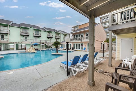 Sparkling pool awaits with comfortable lounge chairs under your private covered patio—perfect for morning coffee or afternoon relaxation between swims.
