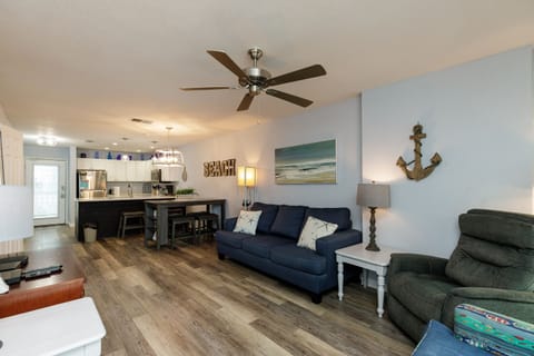 Relax in your spacious open-plan living space with coastal touches, comfortable seating, and a fully equipped kitchen perfect for beach getaways.