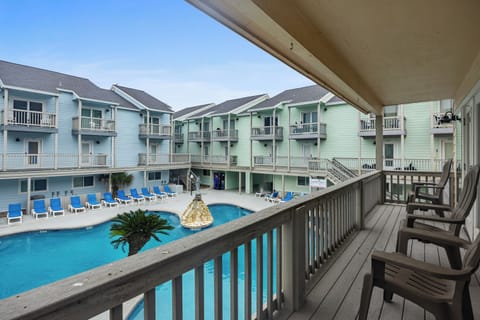 Step onto your private balcony and soak in stunning pool views while colorful beach buildings create a charming coastal backdrop for your getaway.