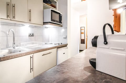 Galley kitchen with fridge, electric oven