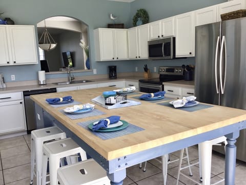 Eat-in kitchen with updated appliances and large sliding doors to the pool.