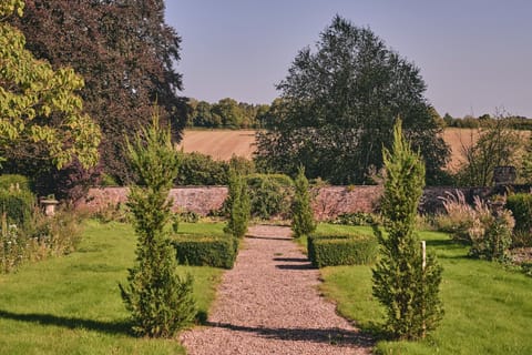 A cobbled pathway through the garden overlooking the countryside at Flock Cottage, Welsh Borders