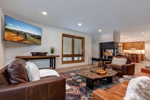 Living room with sleeper sofa, wet bar and beverage fridge, two-sided Gas Fireplace and 65" LG Smart TV
