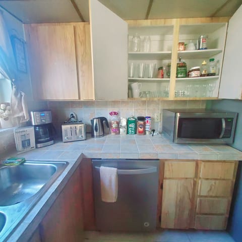 Kitchen have various glasses , pods , baking equipment ,spices , coffee and tea