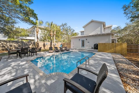 Your private oasis awaits with sparkling pool, sun-dappled loungers, and peaceful outdoor dining under swaying palms.