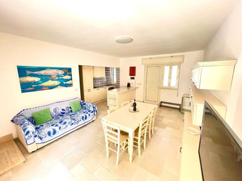 Living area with dining table, TV and sofa.