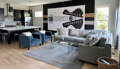 Light Filled Living Room with amazing artwork, oversized custom made sectional sofa, and plush arm chairs. Enjoy a movie on 65" SmartTV