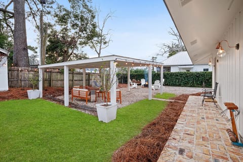 Covered patio with teak furniture, swings, Adirondack chairs, grill & fire pit.